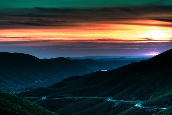 Strada collinare che si estende in un bellissimo tramonto