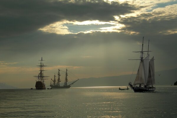 A sailboat and a yacht on the background of a cloudy sky