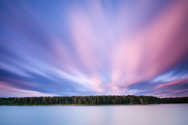 Nuages roses sur la forêt et le lac