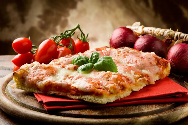 Leckere Pizza auf einer roten Serviette , mit Zwiebeln und Tomaten auf einer Holzplatte