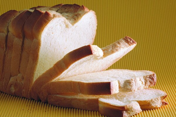 Brotbrötchen auf gelbem Hintergrund schneiden