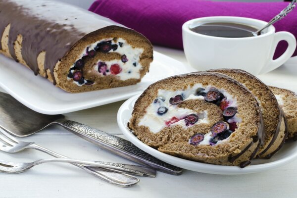 Rollo de chocolate con bayas y taza de té