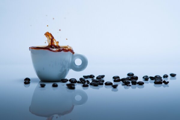 Bicchiere di caffè e chicchi neri sul tavolo