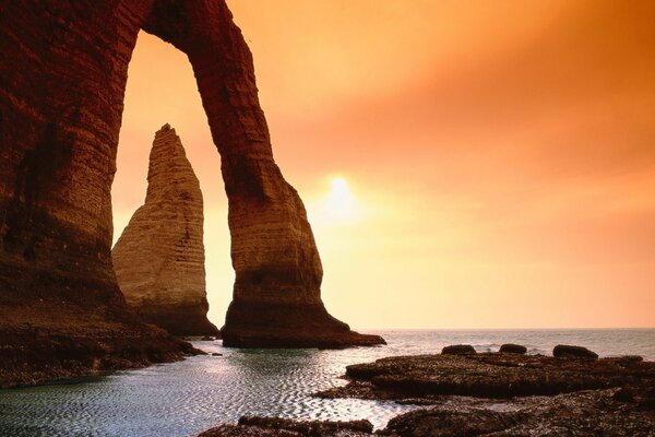 Huge rocks on the seashore against the backdrop of a beautiful sunset