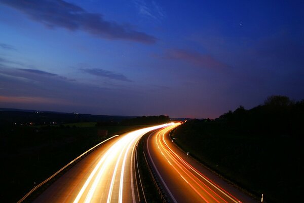 The illuminated road into the distance in the evening