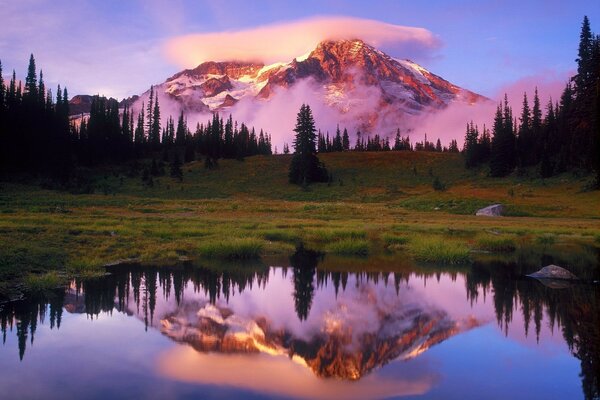 Reflejo en el lago de una gran montaña con nubes