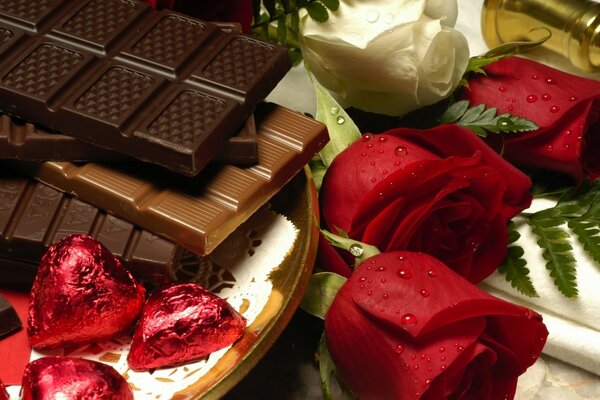 Chocolats, barres de chocolat à côté d un bouquet de roses