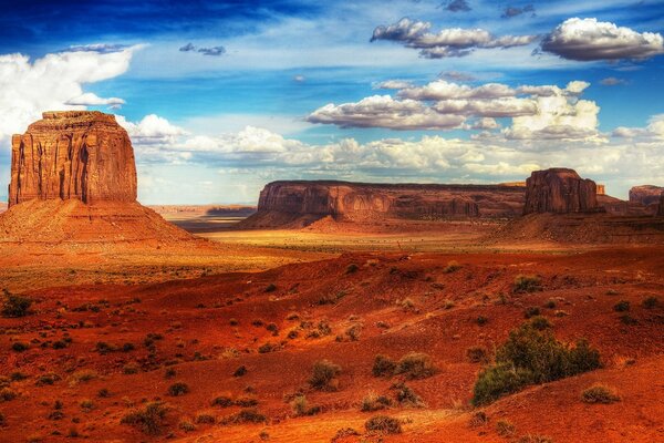 Rocky desert with red sand and a cloudy sky