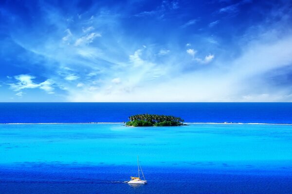 A boat and a small island in the middle of the ocean