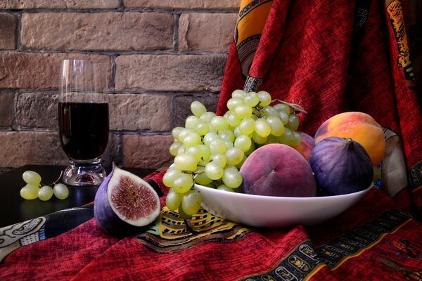 Teller mit Obst und einem Glas Wein