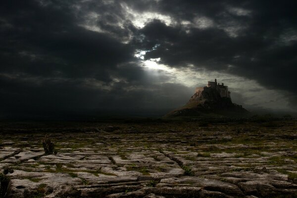 Château sombre dans le désert dans les nuages