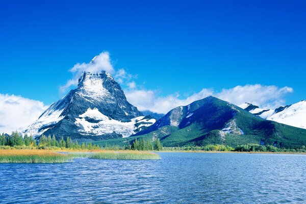 A lake near the mountains. Blue sky with white clouds