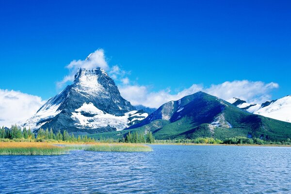 Lago en las montañas. Cielo azul con nubes blancas