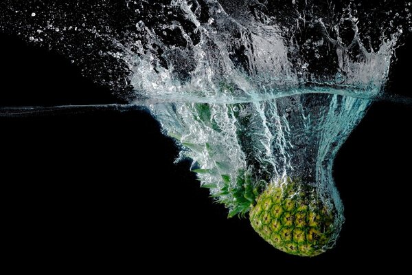 Ananas fiel auf dunklem Hintergrund ins Wasser