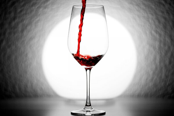 Red wine pours into a glass