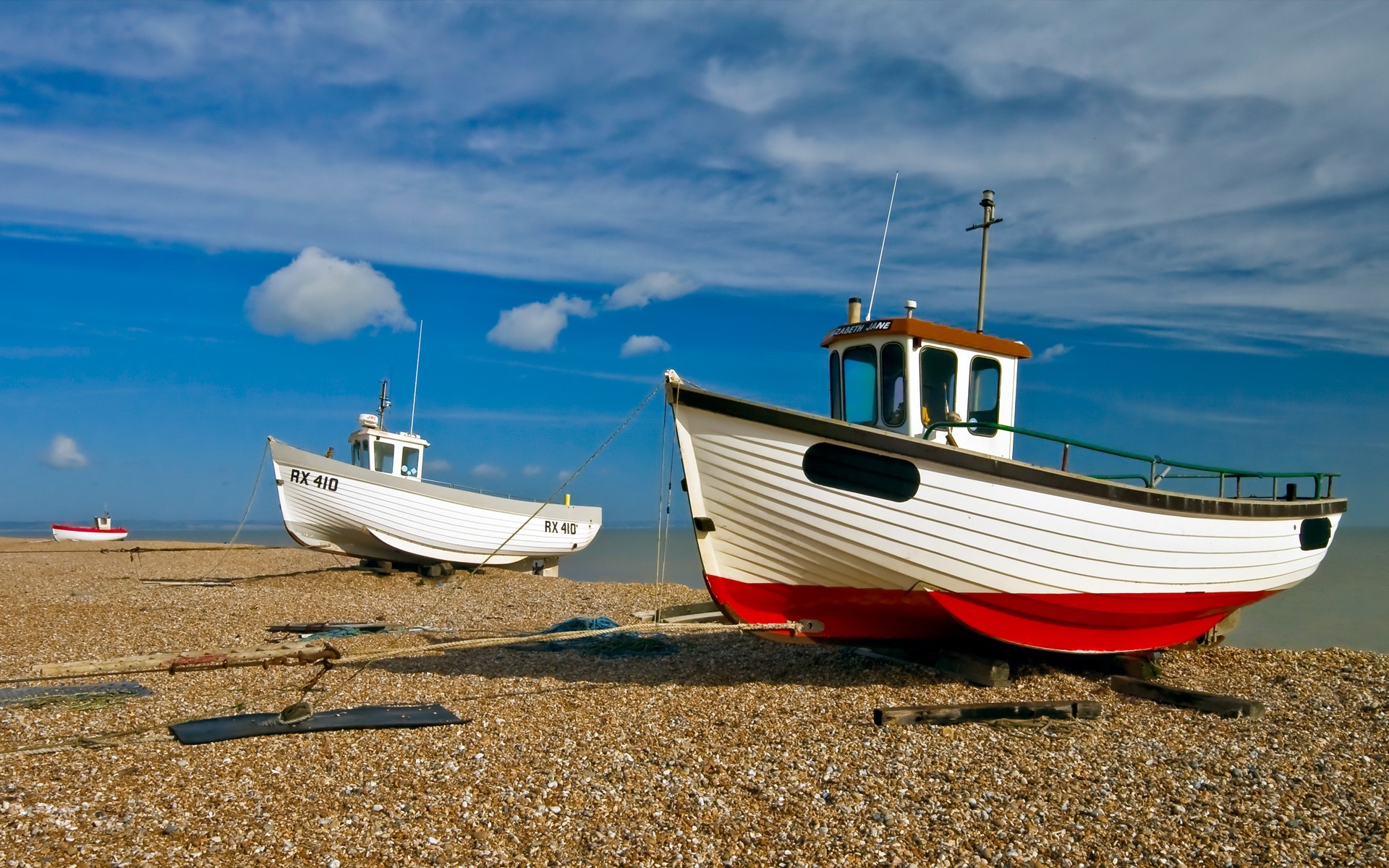 beach boat clouds pebble