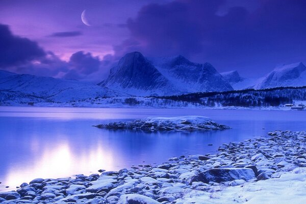 L eau à la lumière de la lune entourée de montagnes enneigées