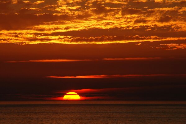 Ocaso naranja de agua en el océano