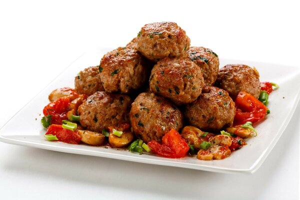 Round cutlets with vegetable side dish on a square plate