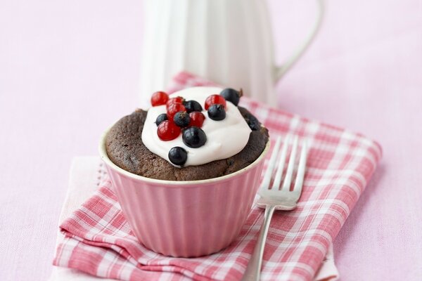 Cupcake decorated with cream and currant berries