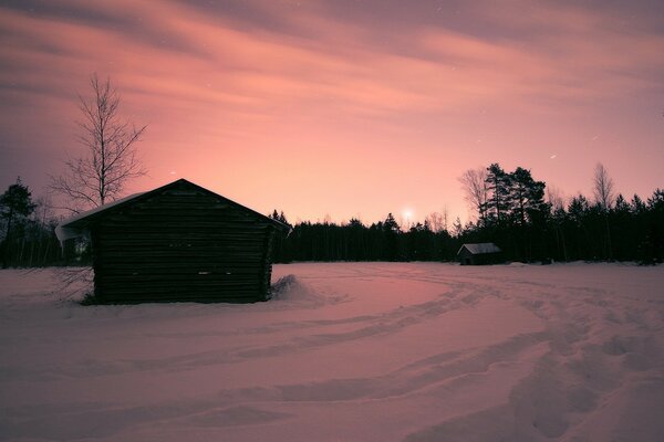 Casa solitaria en medio de un paisaje nevado al atardecer