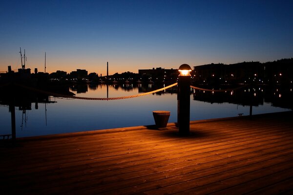 A glowing lantern on the night pier