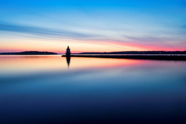 Ruhiges Wasser, das den Sonnenaufgang widerspiegelt