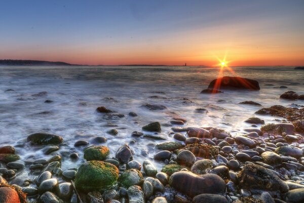 A light breeze blows over the rocks and excites the flow of water