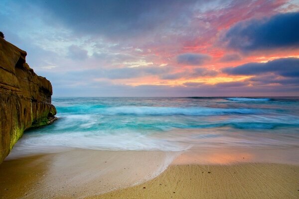 Turquoise water washes the sandy shore