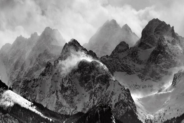 Schwarz-Weiß-Bild von schneebedeckten Bergen und Wolken