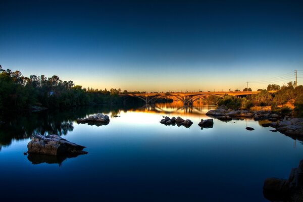 Brücke über den blauen Fluss bei Sonnenuntergang