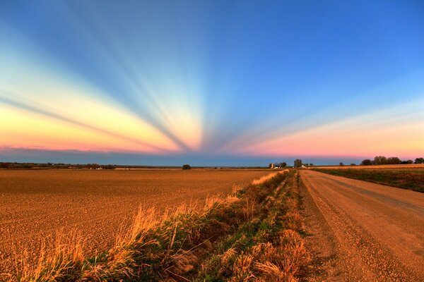 Ungewöhnlicher Himmel, endloses Feld, Straße im Feld