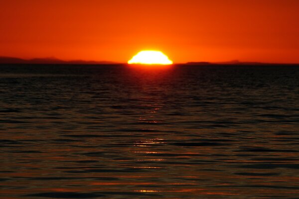 Le soleil rouge est tombé dans l eau