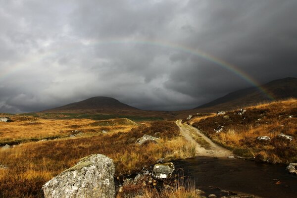 Rainbow on the background of gray thick clouds