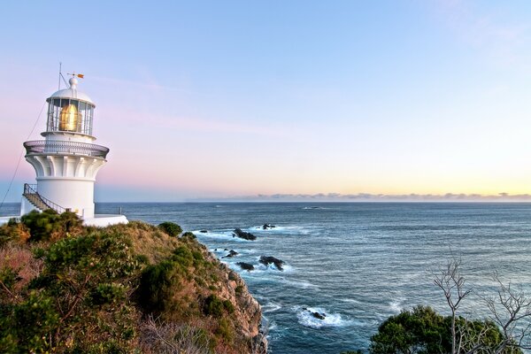 Lighthouse on the seashore at sunrise
