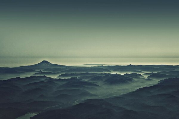 Las montañas de la mañana y el río en la niebla