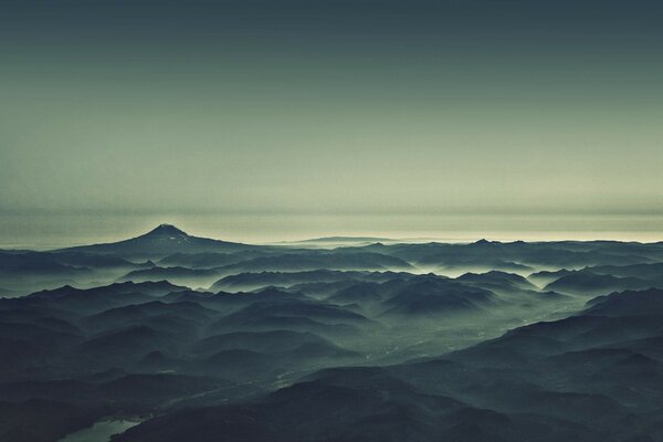 Montagne del mattino e fiume nella nebbia