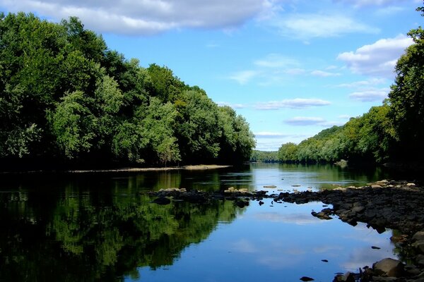 Río tranquilo. Reflejo de las nubes en el agua