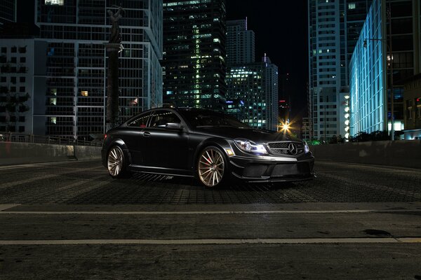 Mercedes noire avec classe sur fond de ville de nuit