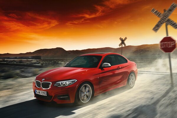 Rotes BMW-Auto auf Sonnenuntergang Hintergrund