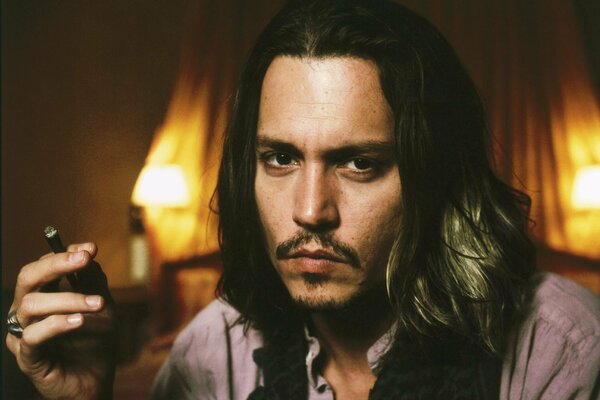 Actor Johnny Depp smokes a cigar