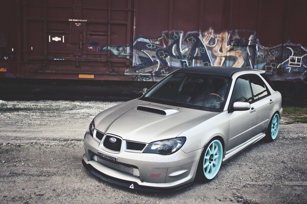 Grey Subaru with blue wheels