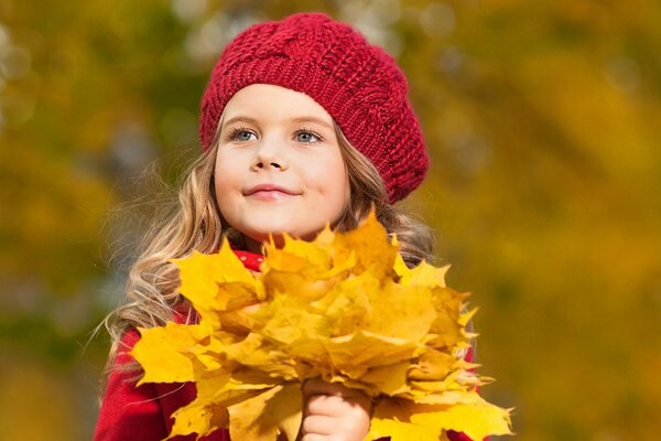 A girl in a red beret with an autumn bouquet