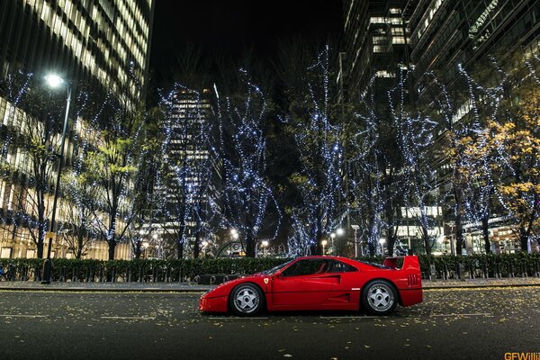 Roter Ferrari nachts in der Stadt