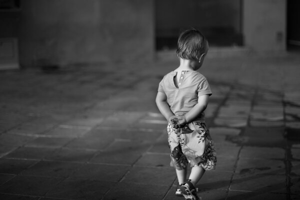 Schwarz-Weiß-Foto eines Jungen auf der Straße