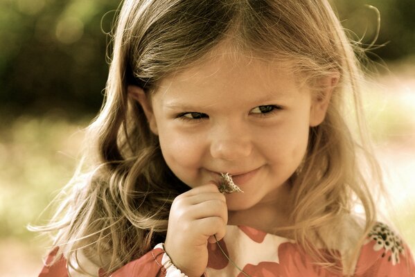 A girl with a daisy. The girl is smiling, a good summer photo