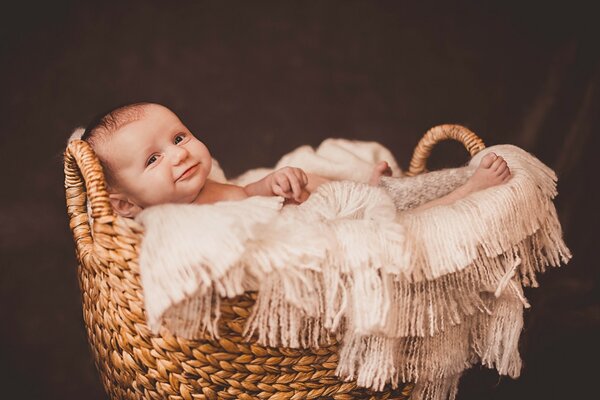 A small child is lying in a basket