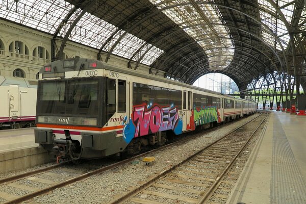 Tren en graffiti en la estación de tren por la tarde