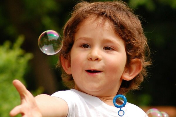 Das Kind lässt Seifenblasen Blasen