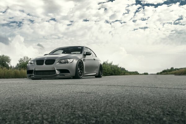 Grey BMW car on the road against the sky